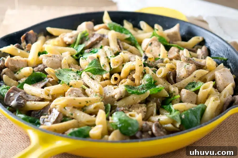 A serving of Chicken Penne with Creamy Mushroom White Wine Sauce on a white plate