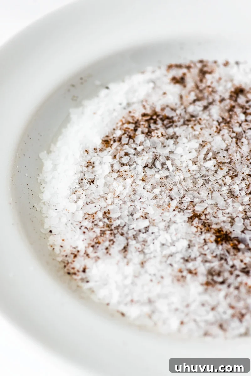 The Ultimate Michelada 3 Flaky sea salt and Tajin seasoning on a white plate, ready to rim a Michelada glass.