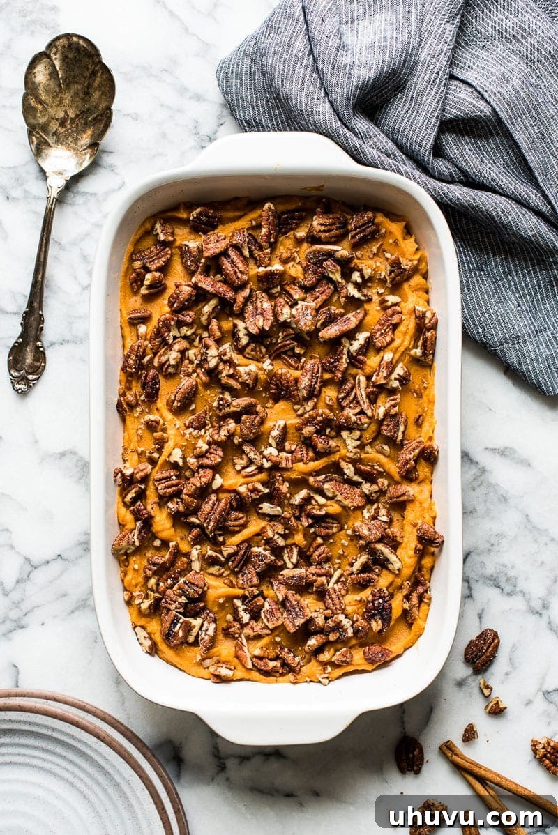 Healthy sweet potato casserole topped with pecans.
