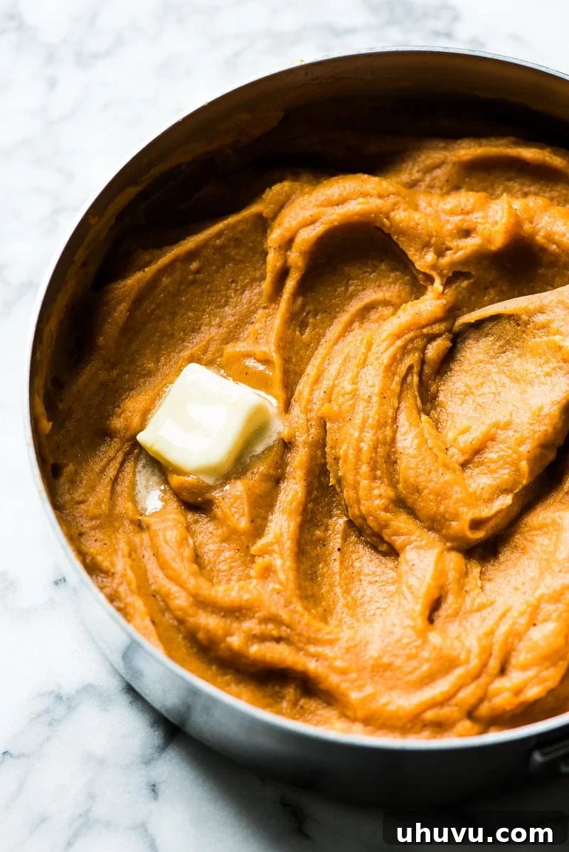 Mashed sweet potatoes topped with butter for a healthy sweet potato casserole.