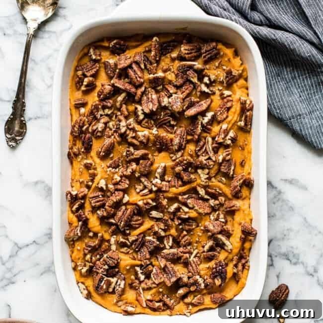 Healthy sweet potato casserole topped with candied pecans.