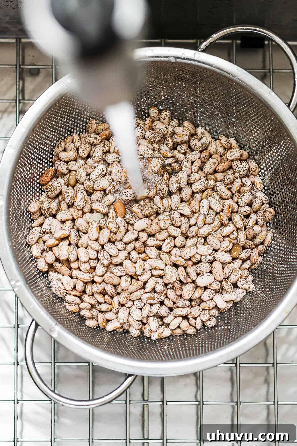 Easy Slow Cooker Pinto Beans 4 Pinto beans being rinsed in a strainer.