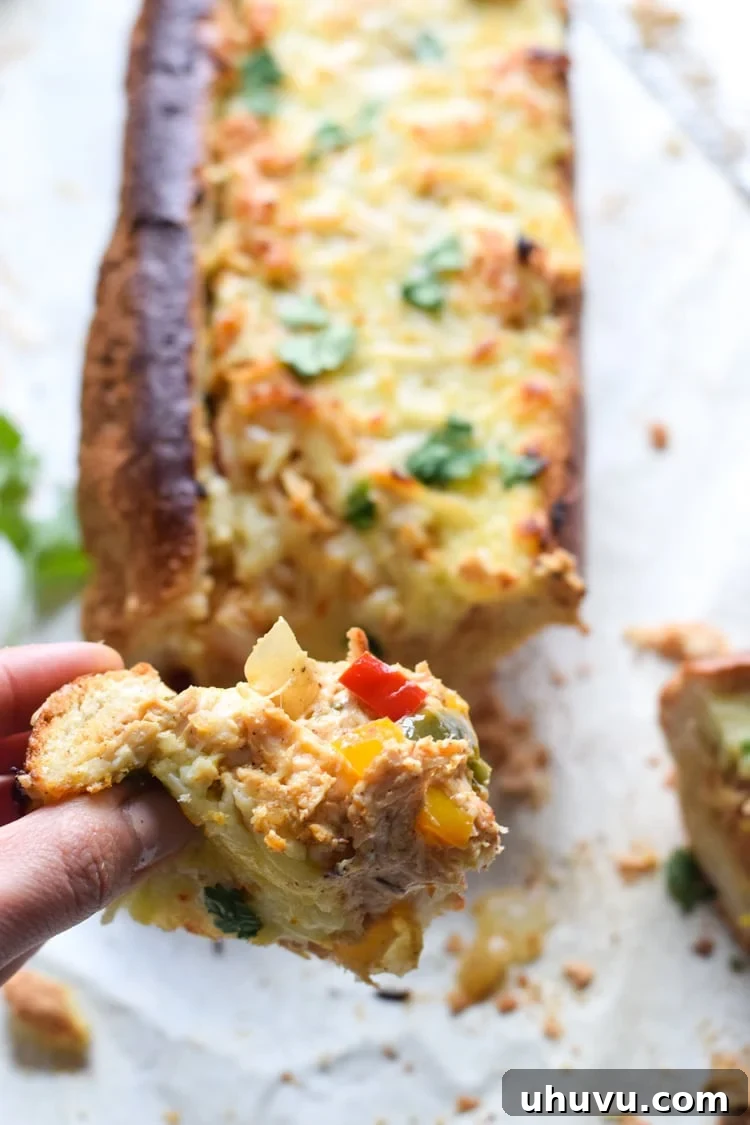Freshly baked Chicken Fajita Stuffed French Bread, golden and bubbly, with melted cheese and a sprinkle of green cilantro on top.