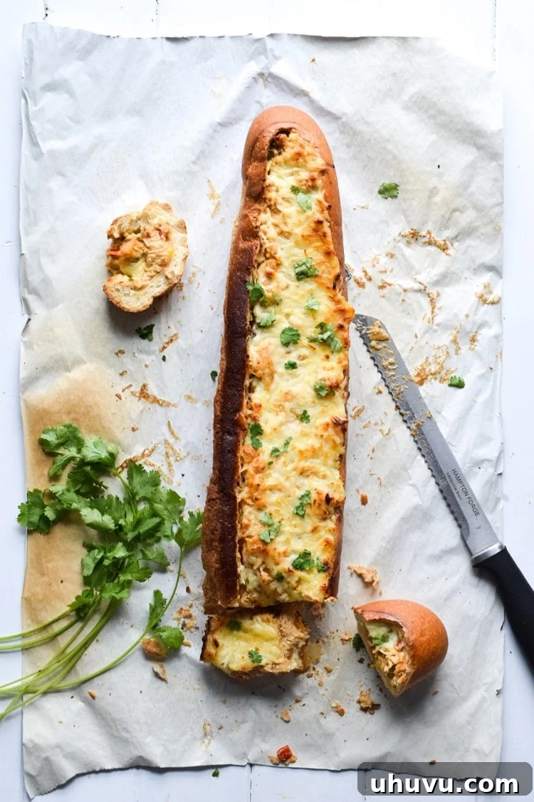 A close-up of a single slice of Chicken Fajita Stuffed French Bread, showing the rich, multi-layered filling and crispy bread crust.
