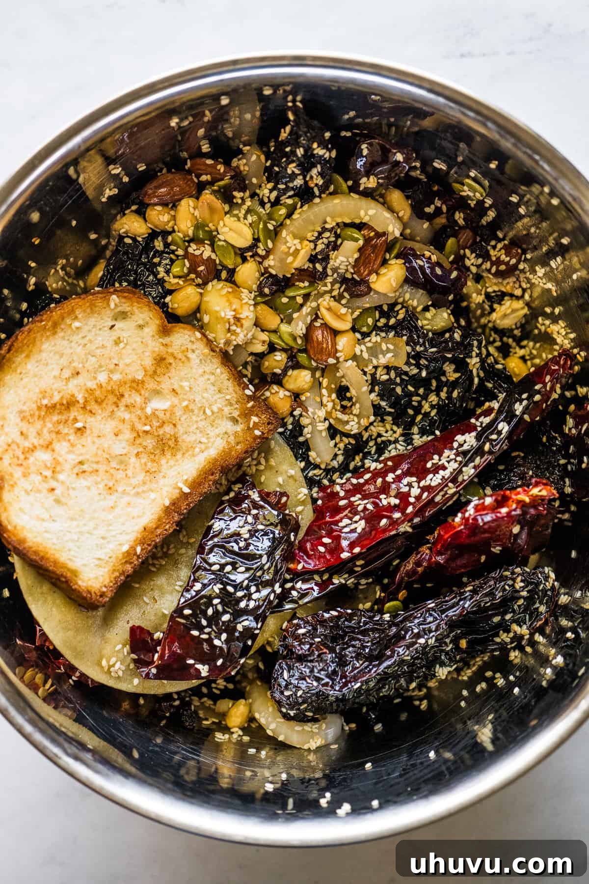 Classic Mexican Mole Poblano Sauce 7 All the toasted ingredients for mole sauce soaking in a bowl filled with hot chicken broth.