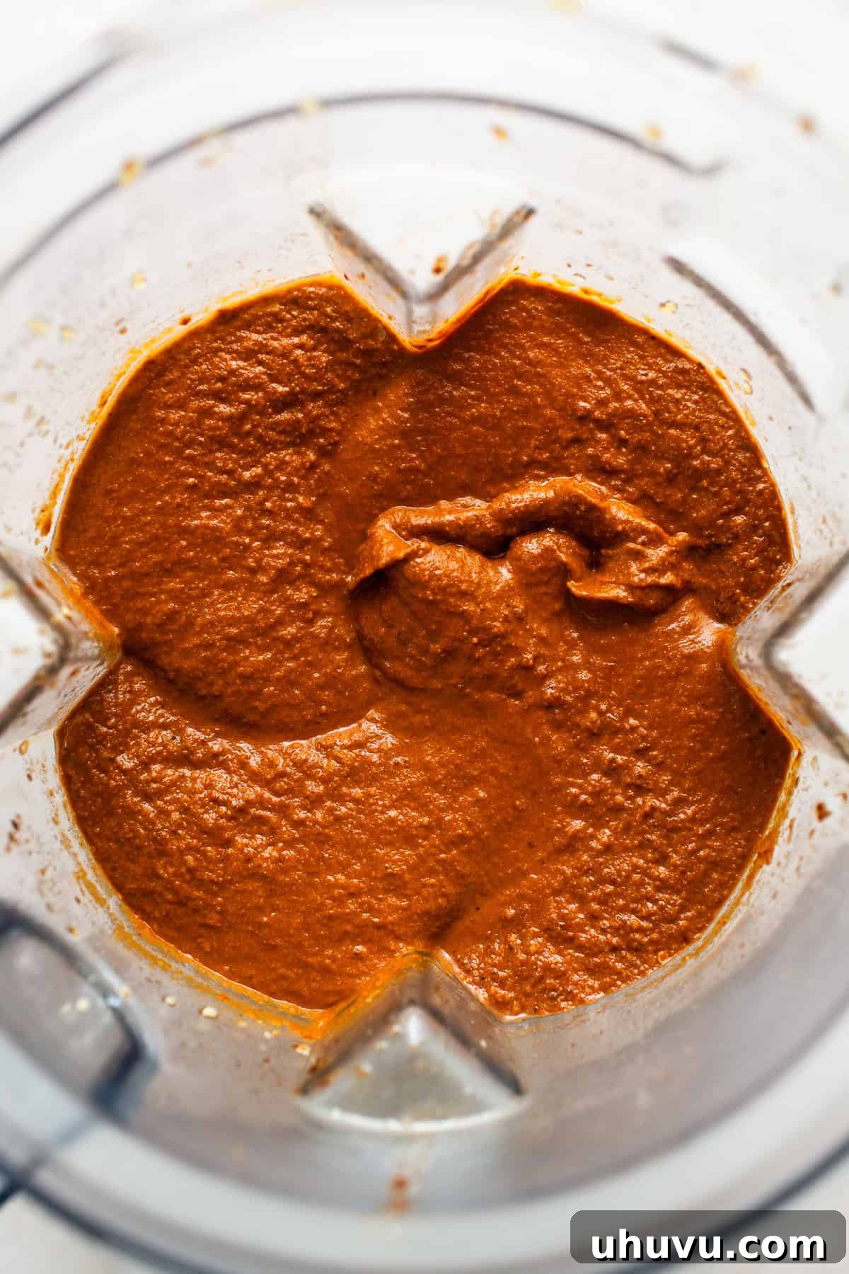 Classic Mexican Mole Poblano Sauce 8 A high-speed blender actively blending the soaked mole sauce ingredients into a smooth, rich paste.