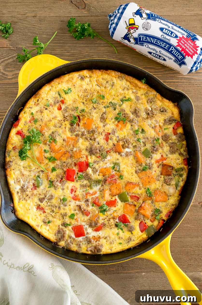 A wedge of Sweet Potato Sausage Frittata served on a white plate with fresh green salad