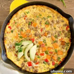 Sweet Potato Sausage Frittata final dish, garnished with fresh herbs in a skillet