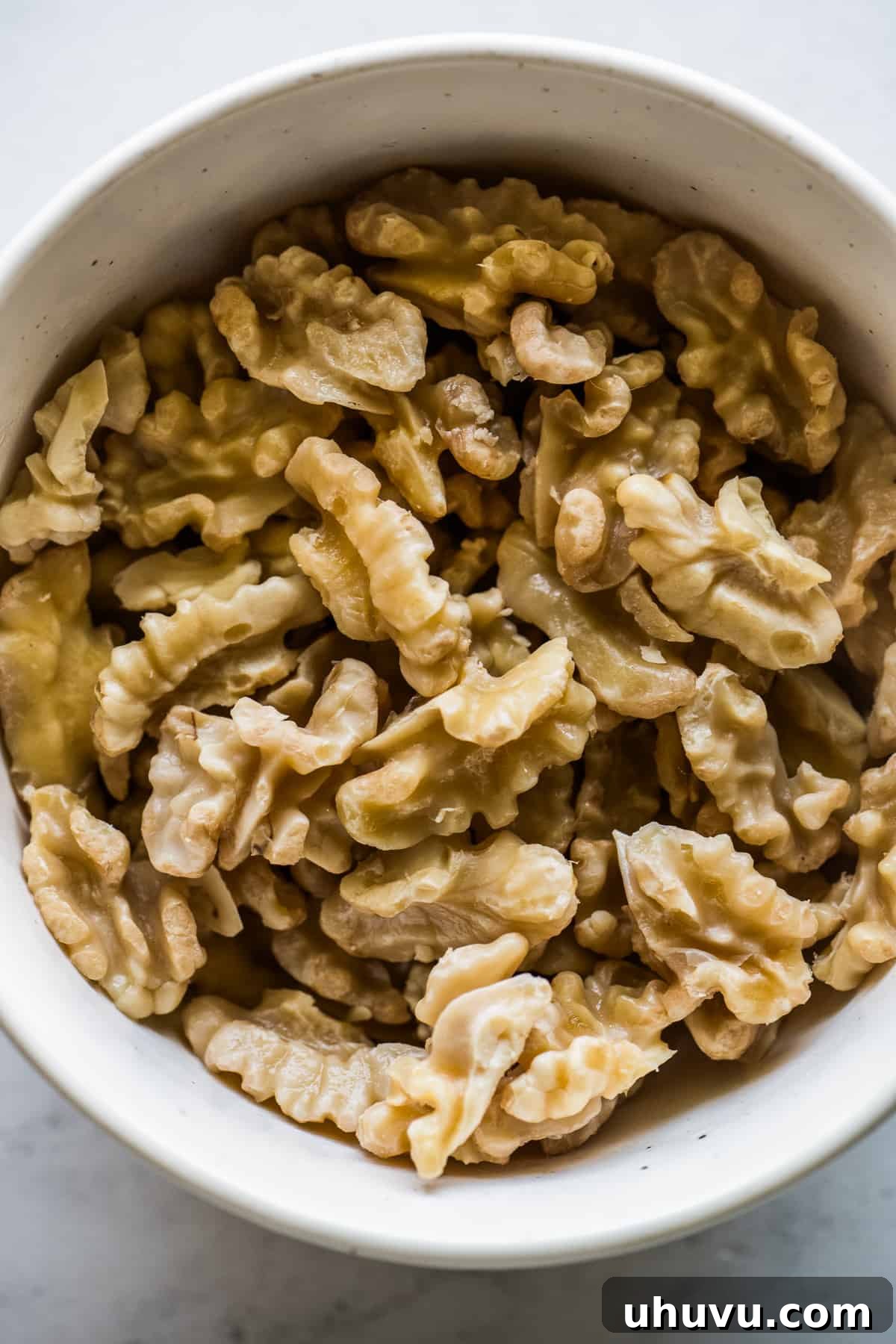 Shelled and skinned/peeled walnuts in a bowl.