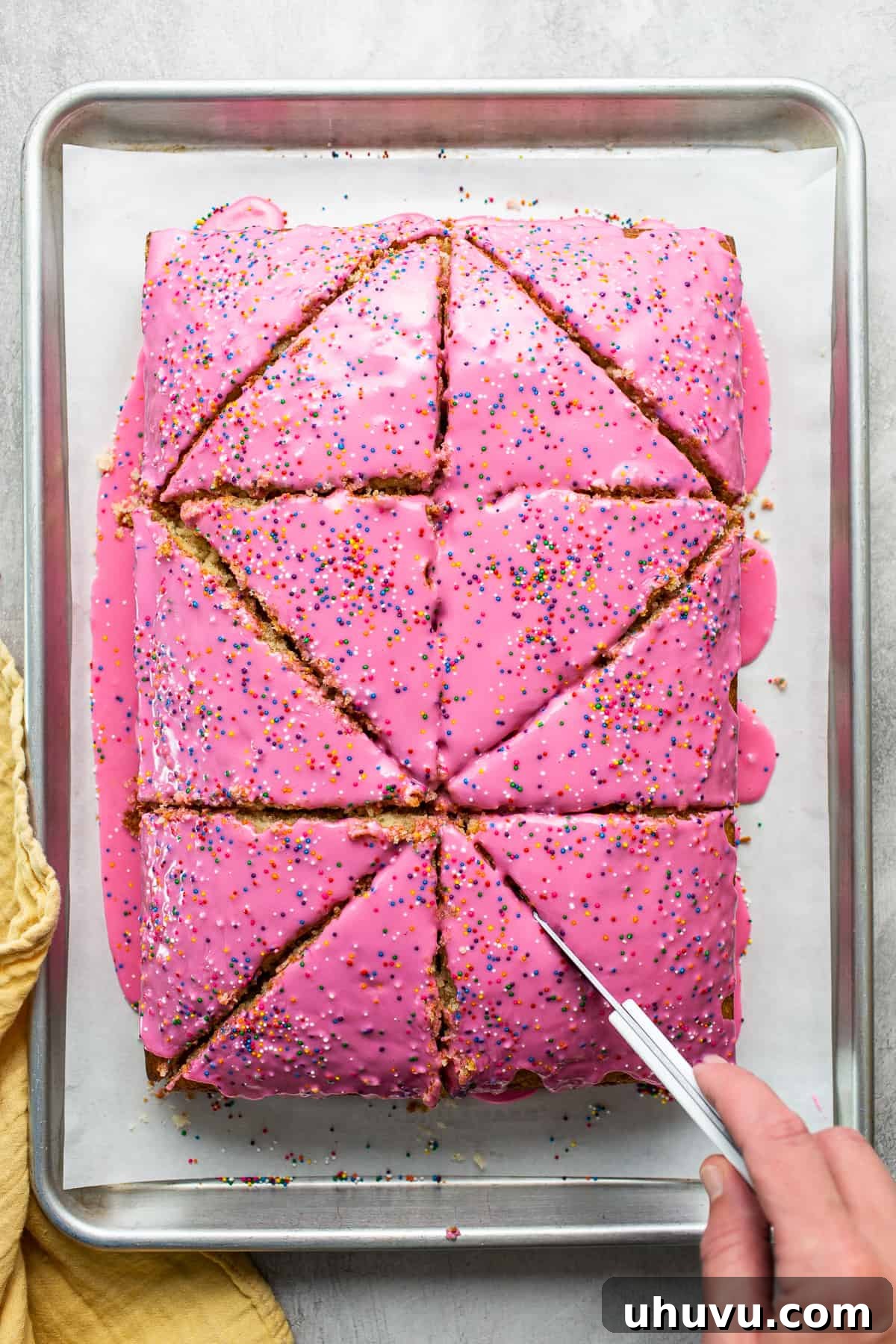 Mexico's Iconic Pink Cortadillo 7 Cortadillo bread being sliced into large triangles, revealing its soft texture and pink icing.