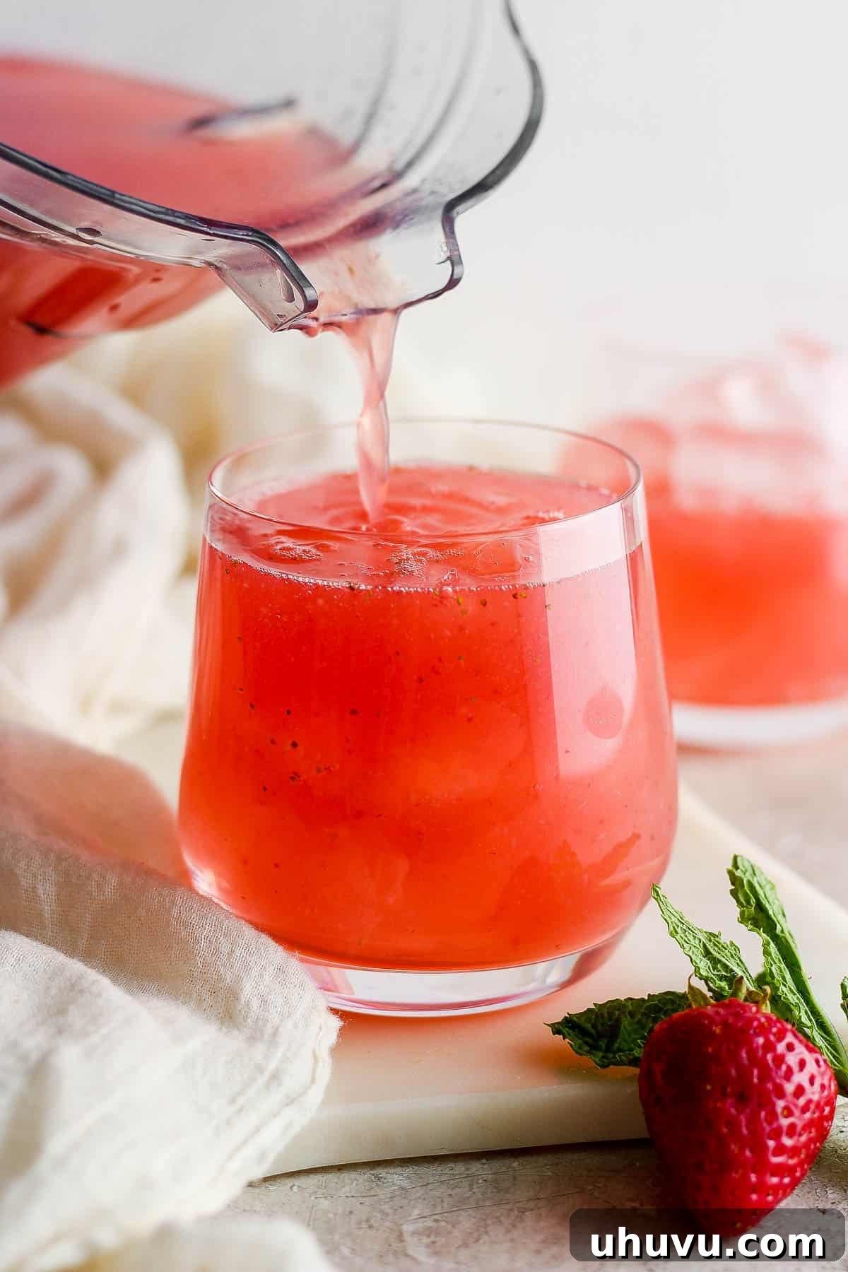 Refreshing Strawberry Sip 7 Strained agua de fresa (Strawberry agua fresca) being poured into a glass.