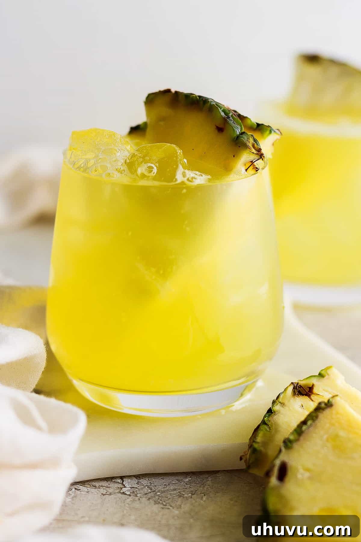 Tropical Pineapple Quencher 2 Agua de pina in a glass with ice.