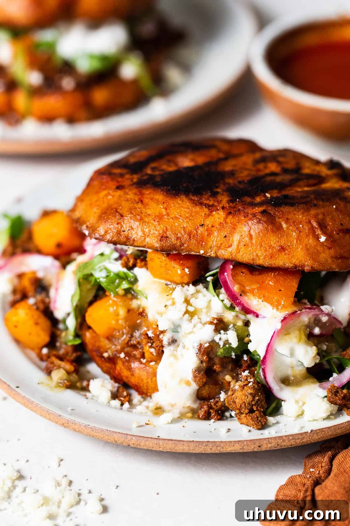 Pambazos on a plate with a potato and chorizo filling spilling out.