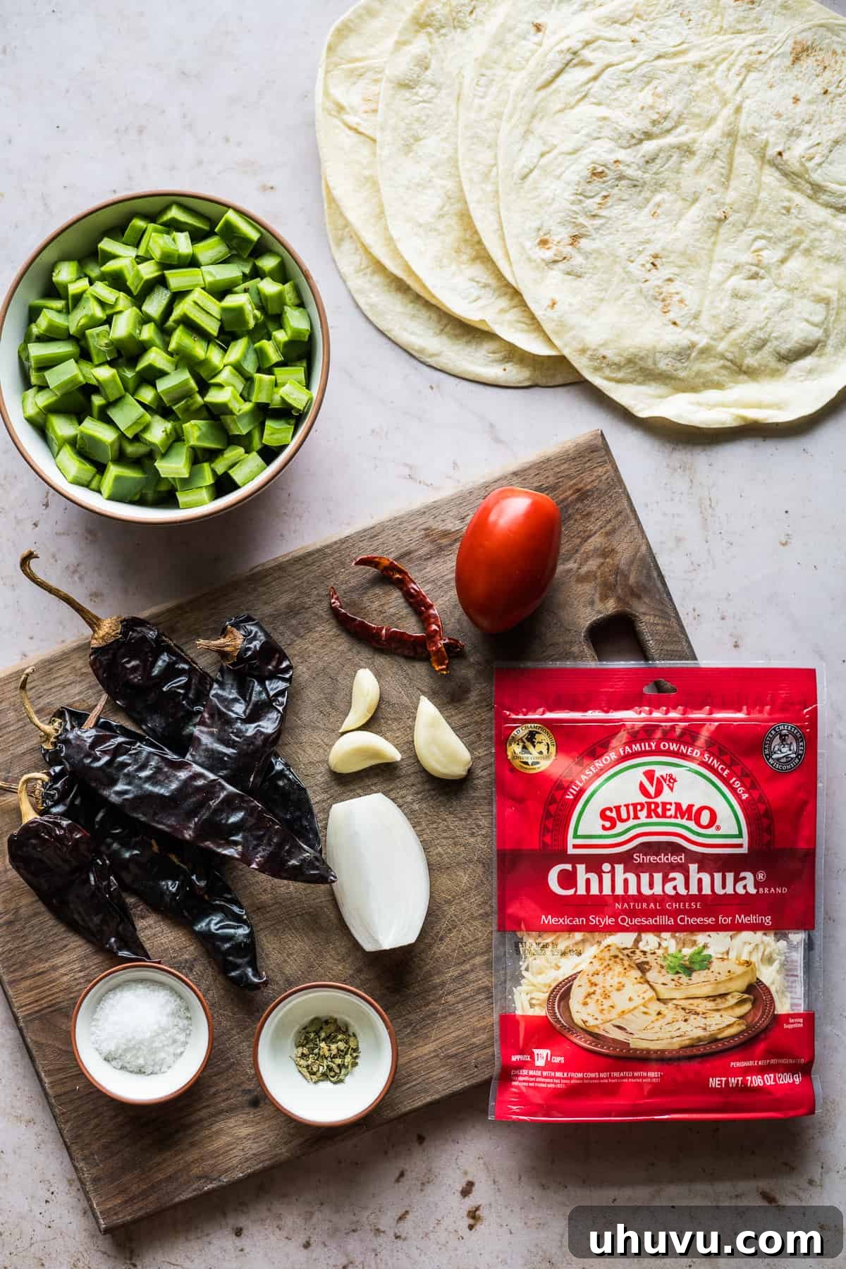 Spicy Nopal Quesadillas 3 Key ingredients for making Quesadillas de Nopales en Chile Rojo, including nopales, chiles, and cheese.