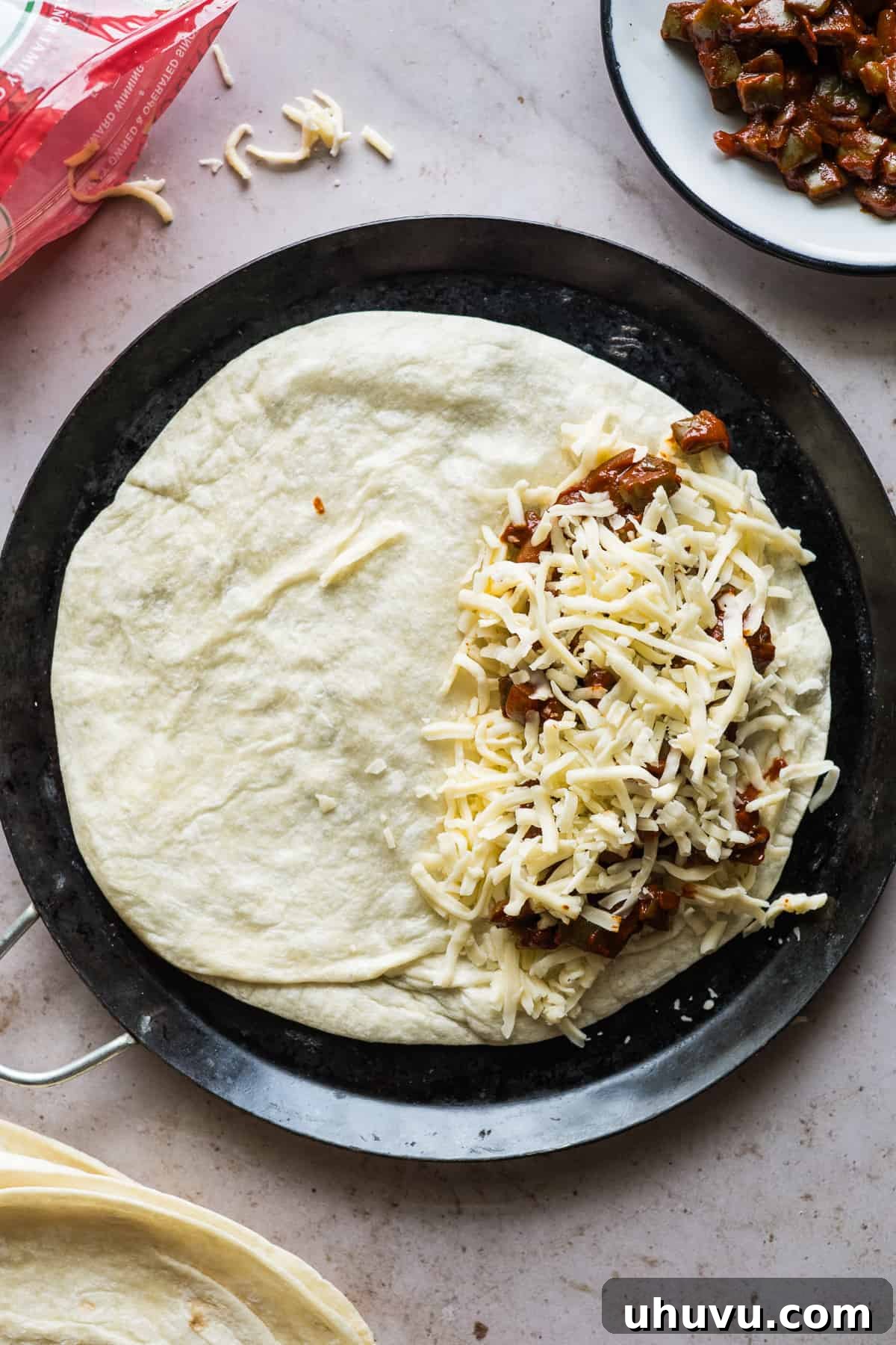 Spicy Nopal Quesadillas 10 A large flour tortilla generously layered with Chihuahua Mexican cheese, savory nopales in red chile sauce, and more cheese, ready to be folded.