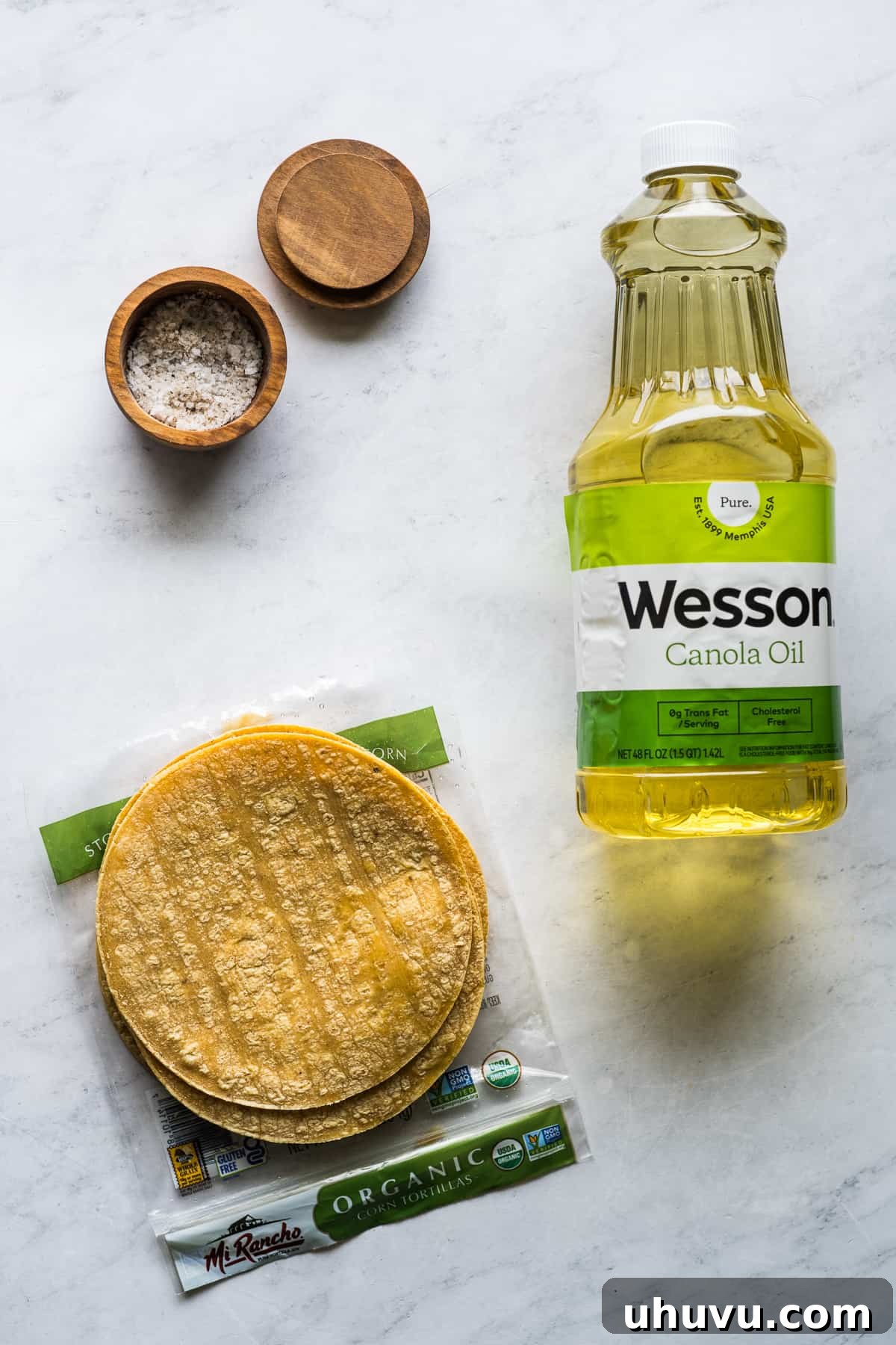 Tortilla Crisps 3 A visual display of the minimal ingredients needed for making tortilla strips: corn tortillas, a bottle of cooking oil, and a small dish of salt.