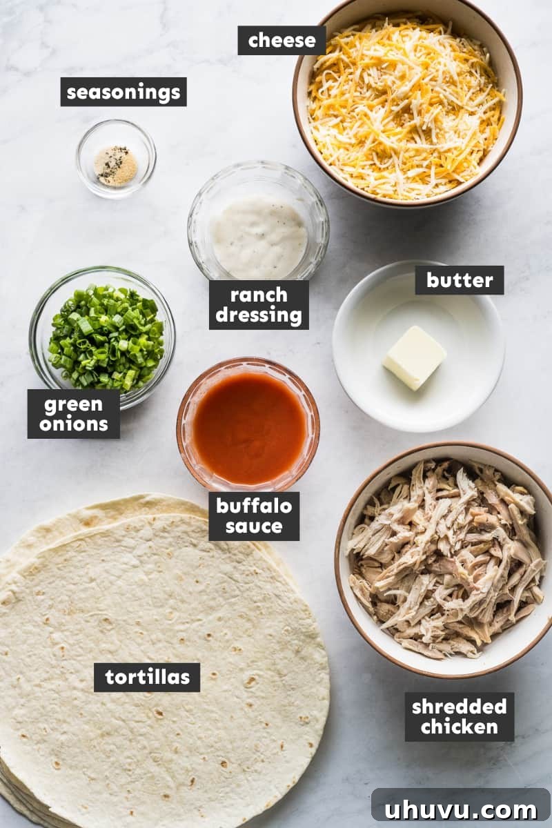 Zesty Buffalo Chicken Melts 3 Fresh ingredients for buffalo chicken quesadillas including shredded chicken, buffalo sauce, cheese, tortillas, and seasonings laid out on a table.
