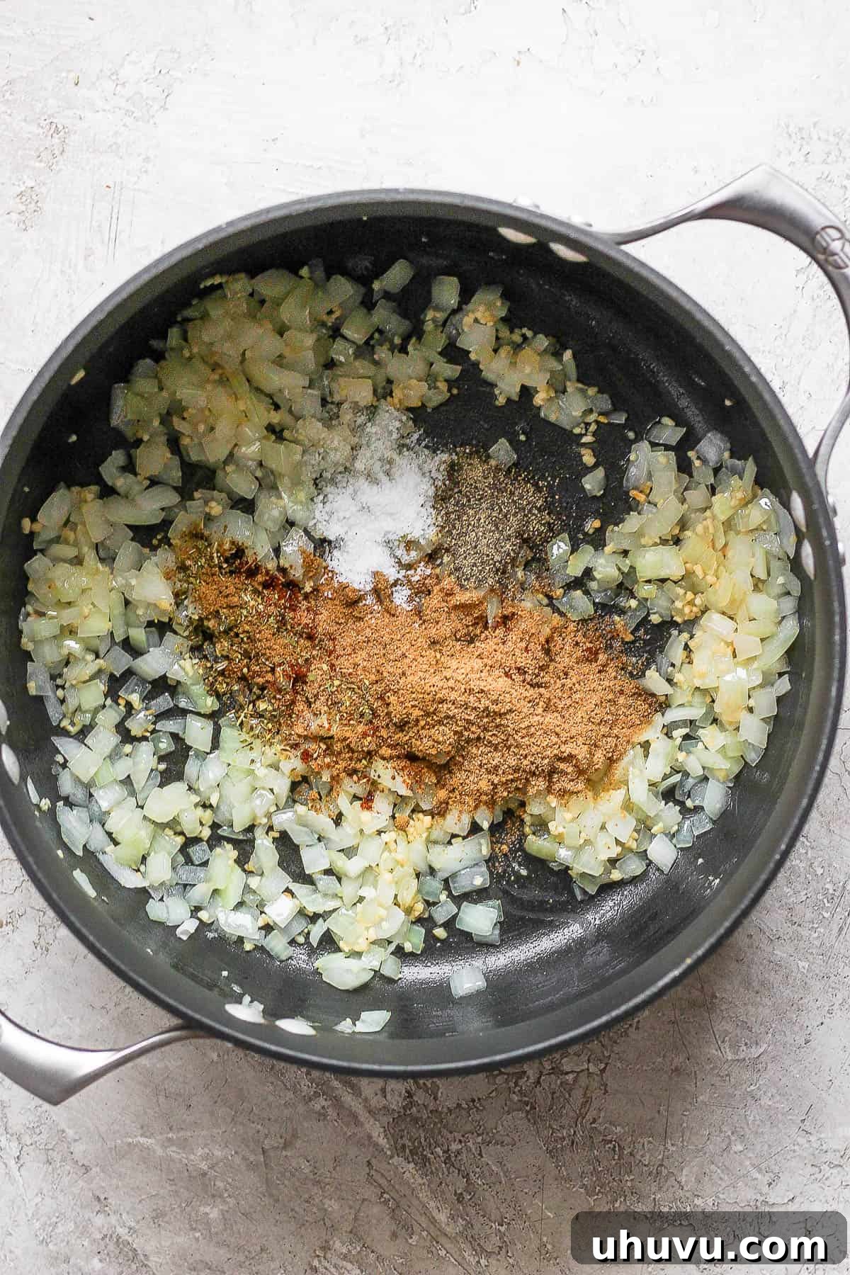 Diced onions and minced garlic gently sizzling in olive oil within a large pot, filling the kitchen with fragrant aromas.