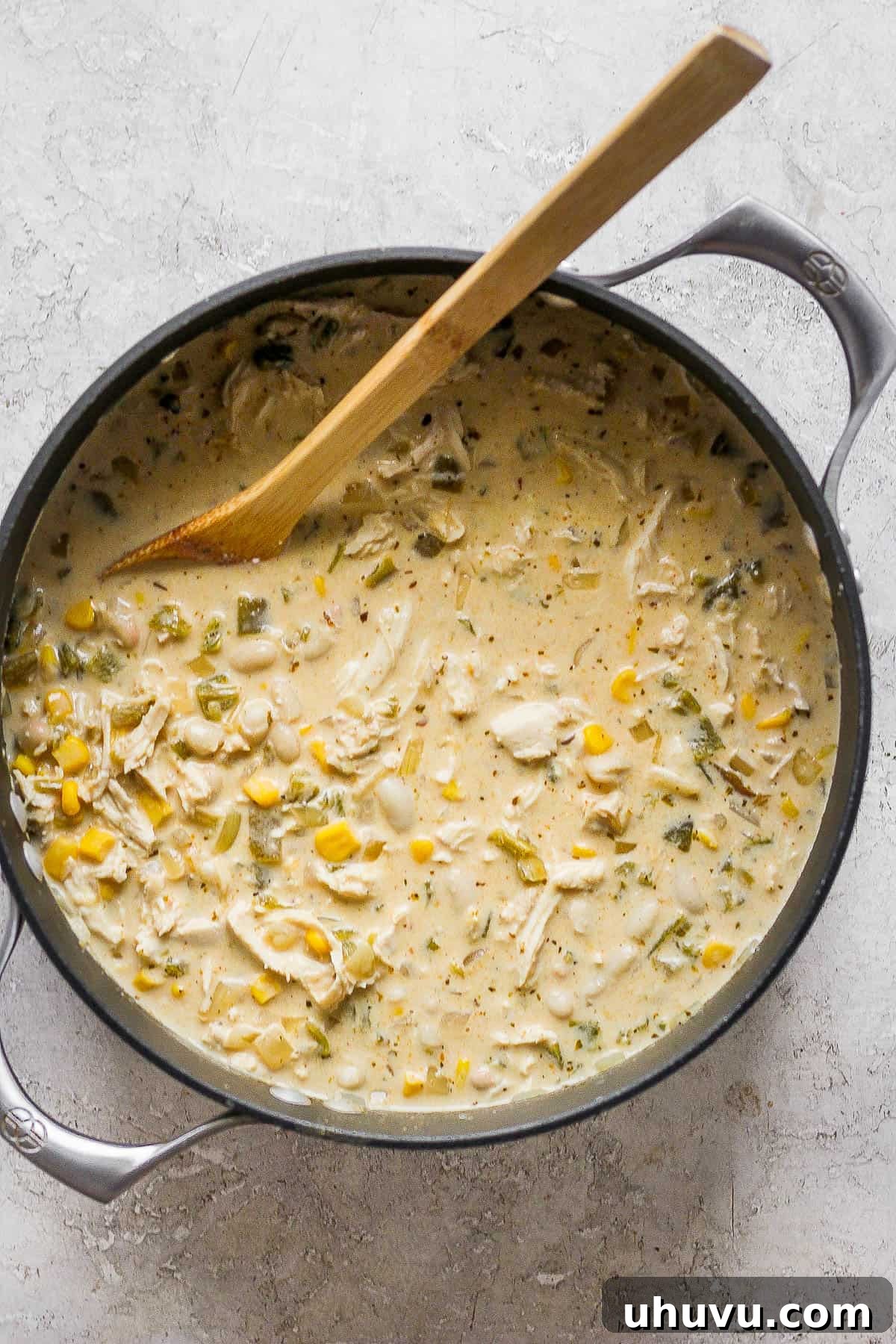 A large pot filled with steaming white chicken chili, garnished with fresh cilantro, ready to be served and enjoyed.