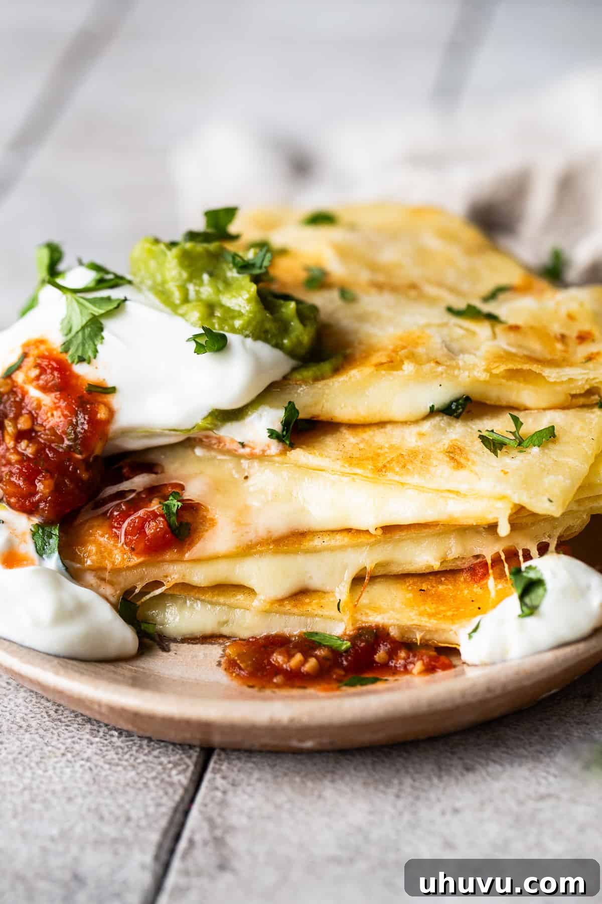 Cheese quesadillas on a plate stacked on top of each other.