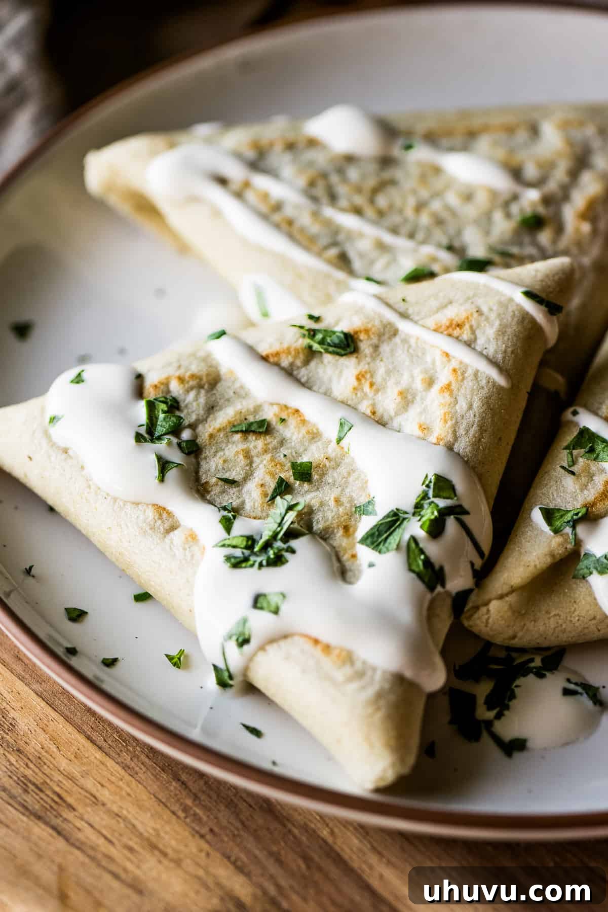 Mexican Masa Pockets 14 Tetelas on a plate garnished with Mexican crema and cilantro.