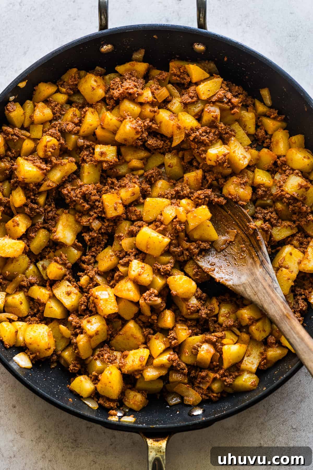 Papas con chorizo filling sizzling in a large skillet.