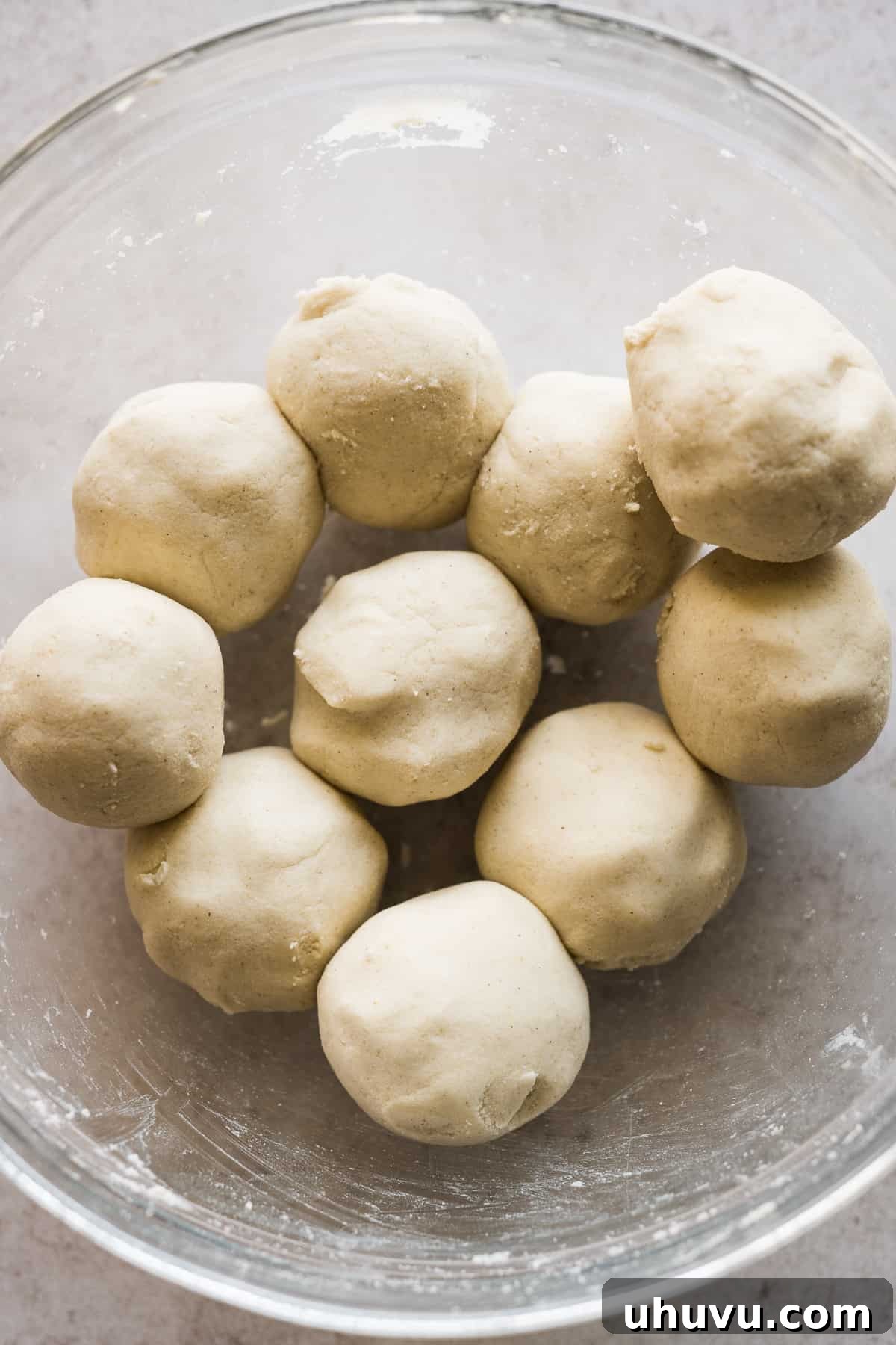 Ten evenly sized balls of masa harina dough in a bowl.