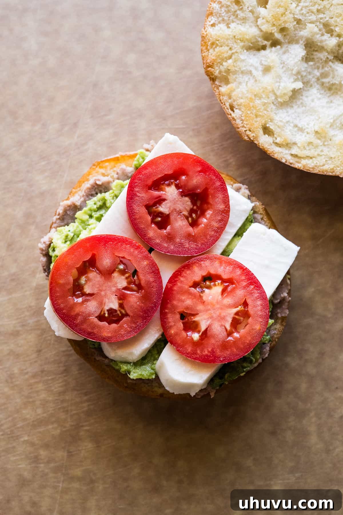 Authentic Mexican Torta 12 Tomatoes, queso fresco, refried beans, and guacamole layered on a telera roll.