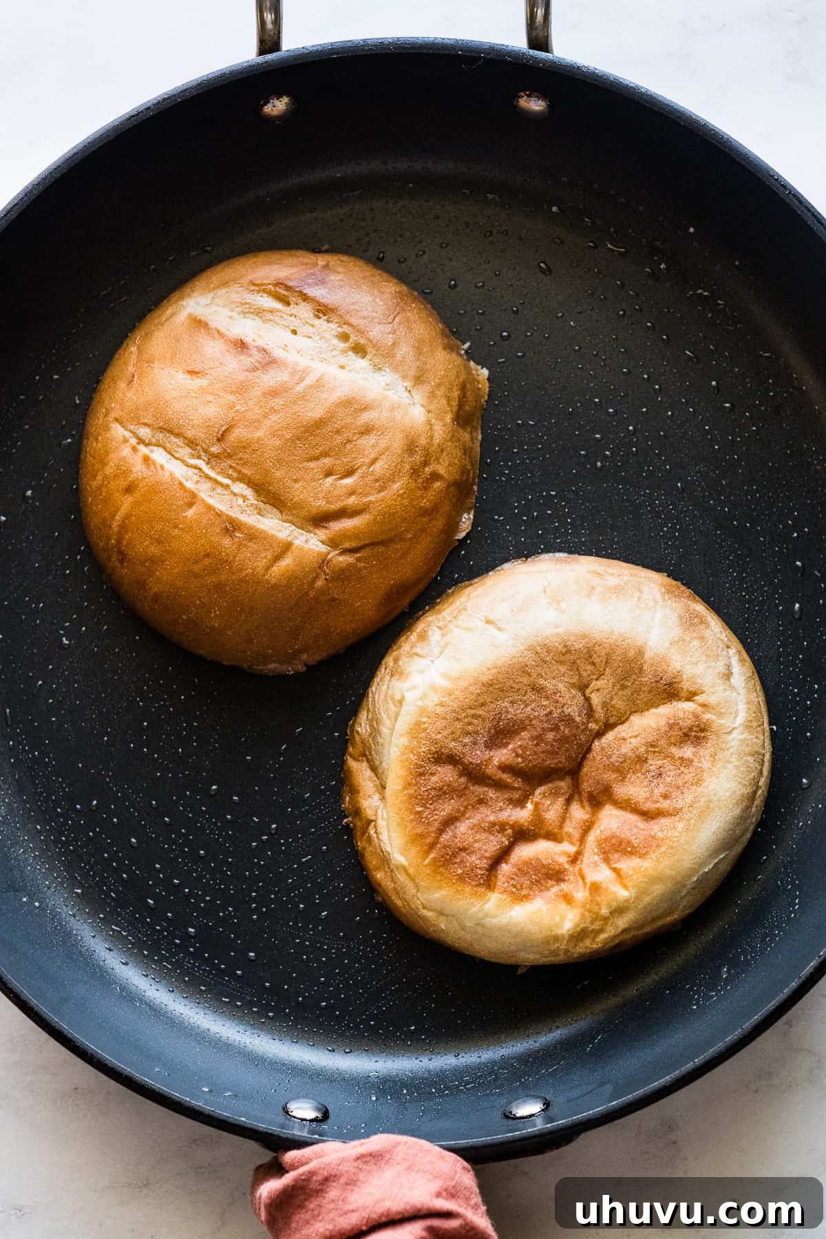 Authentic Mexican Torta 7 Telera bread halves lightly toasting in a skillet with a touch of butter.