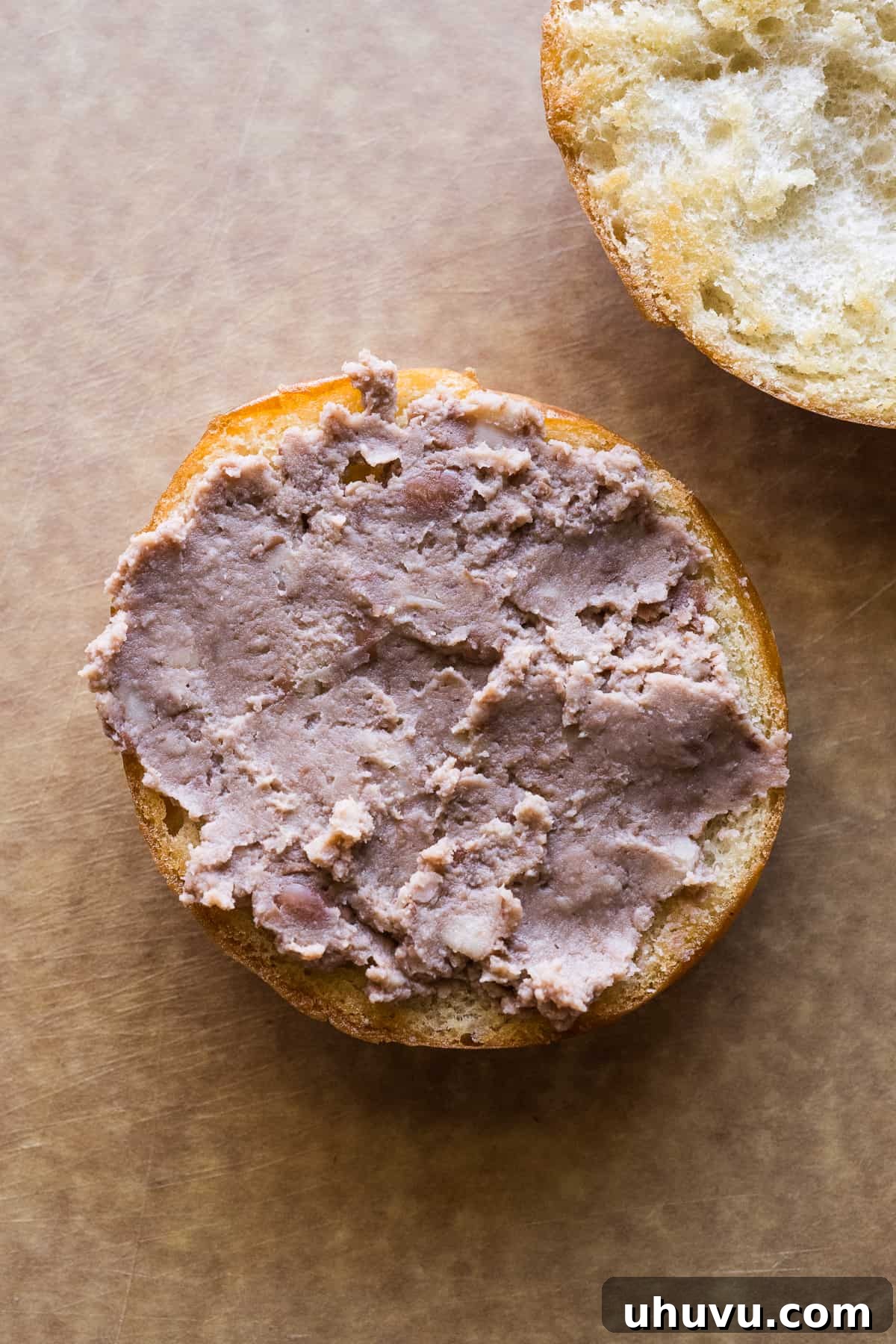 Authentic Mexican Torta 9 Refried beans expertly smeared on the bottom half of a telera roll.