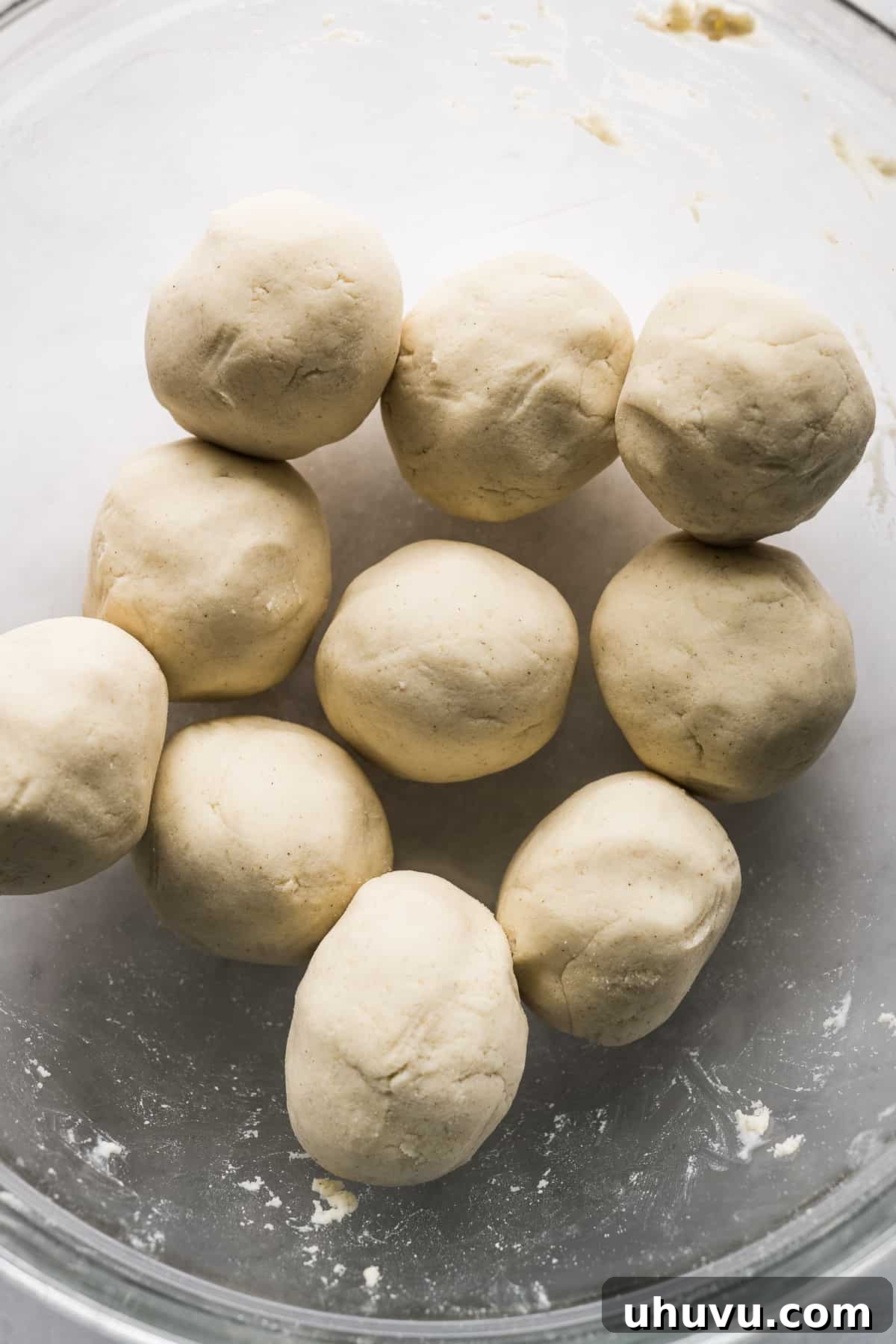 Golden Fried Cheesy Pockets 5 Neatly rolled balls of fresh masa dough resting in a bowl, covered and ready for pressing.