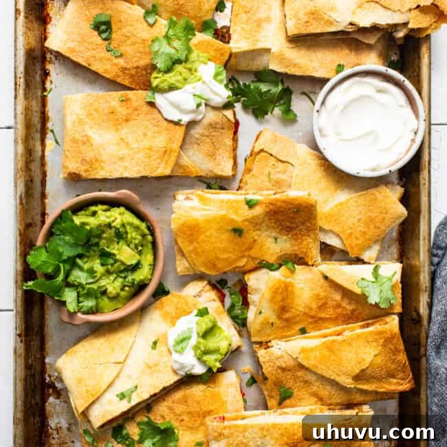 Sheet pan quesadillas, served with sour cream and guacamole, ready to eat.