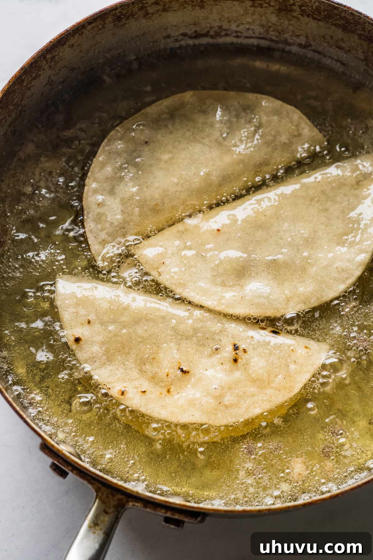 Golden Crispy Tacos 8 Tacos dorados frying in oil.