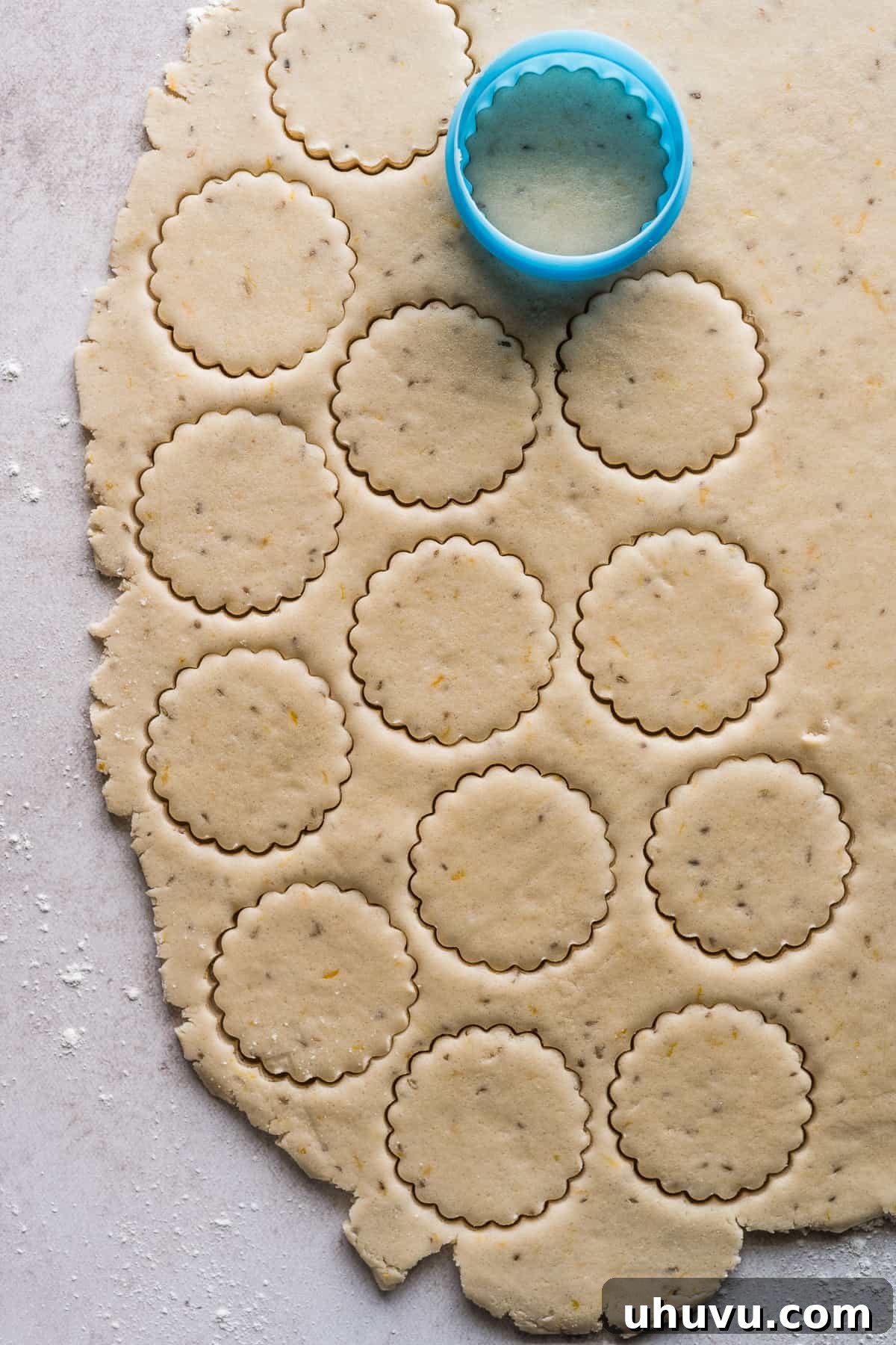Biscochitos being stamped out with a cookie cutter.