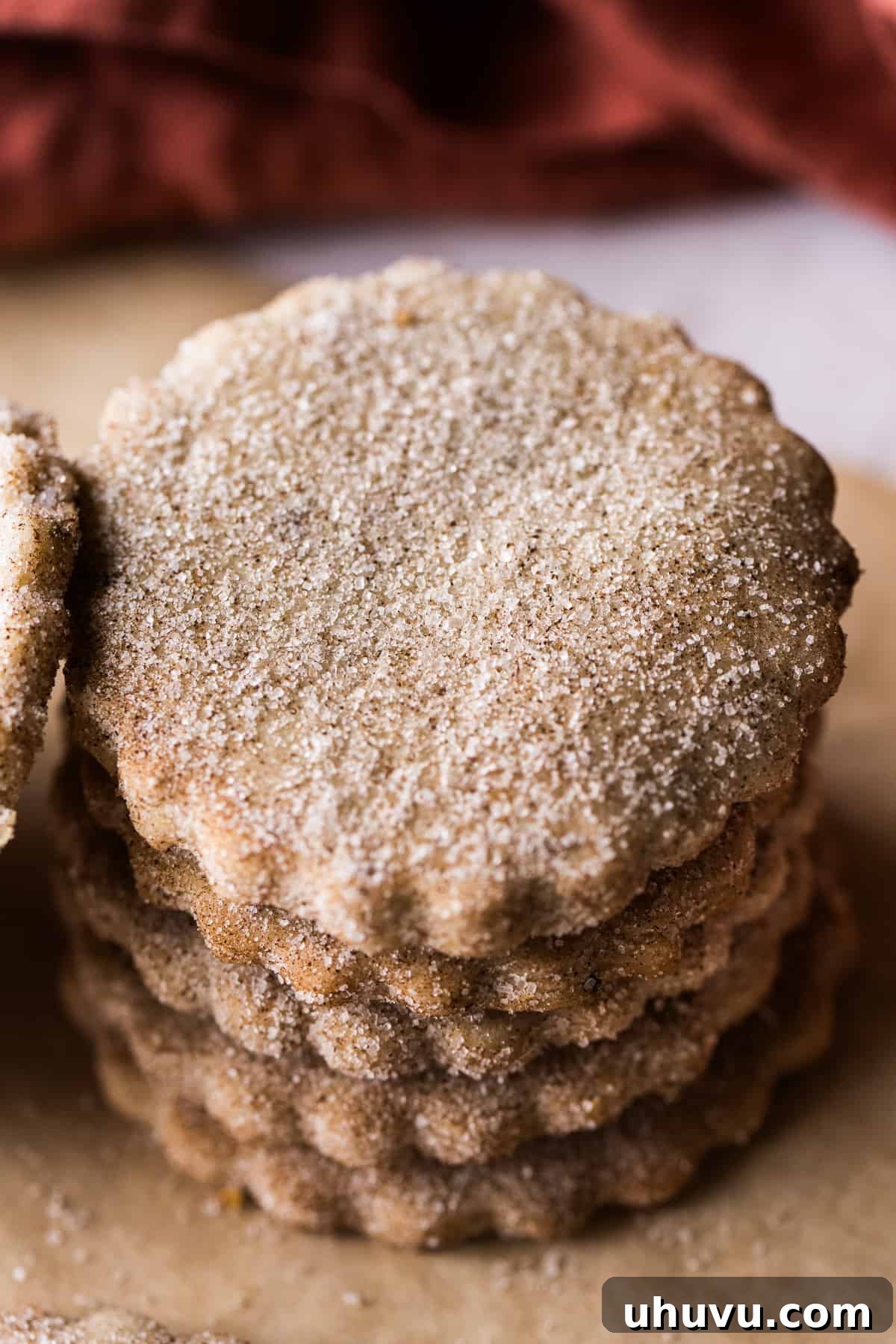 Biscochitos stacked on top of one another coated in cinnamon sugar.