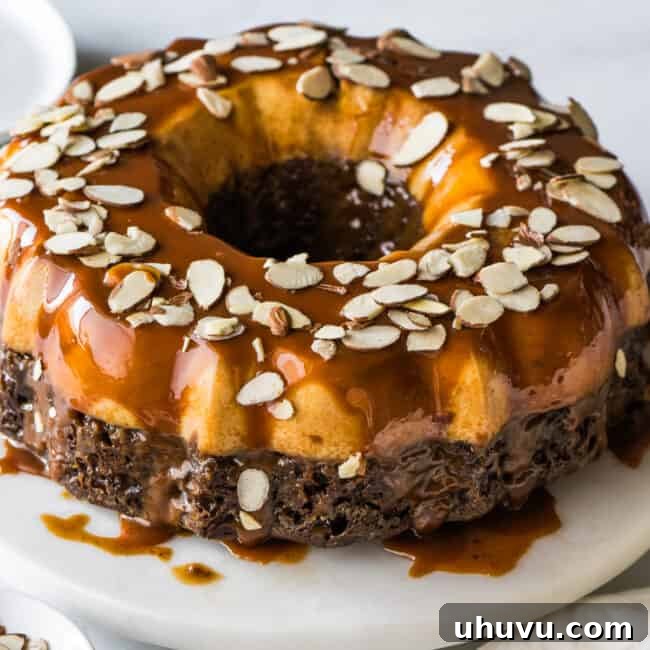 Chocolate Flan Fusion 14 The beautiful, fully assembled chocoflan, inverted to show the flan layer on top, generously drizzled with cajeta and garnished with sliced almonds, presented on a elegant cake stand.