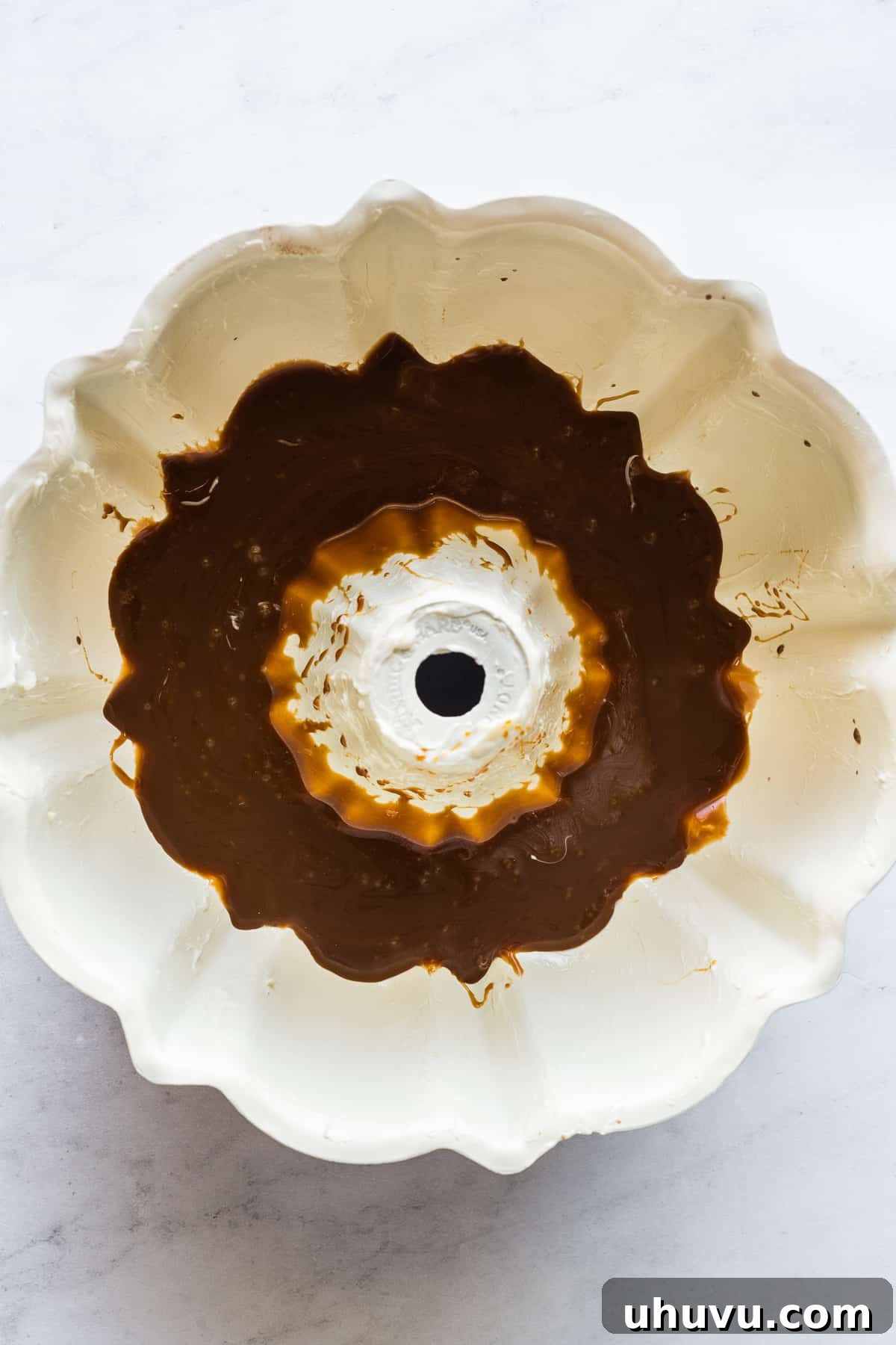 Chocolate Flan Fusion 4 A bundt pan, meticulously greased with butter, with a gleaming layer of rich cajeta caramel coating its bottom, ready for the batters.