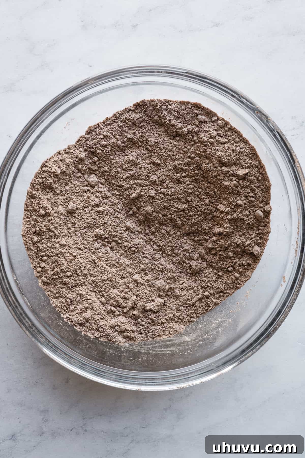 Chocolate Flan Fusion 6 The meticulously measured dry ingredients for the chocolate cake – flour, cocoa powder, baking soda, and salt – awaiting combination in a large mixing bowl.