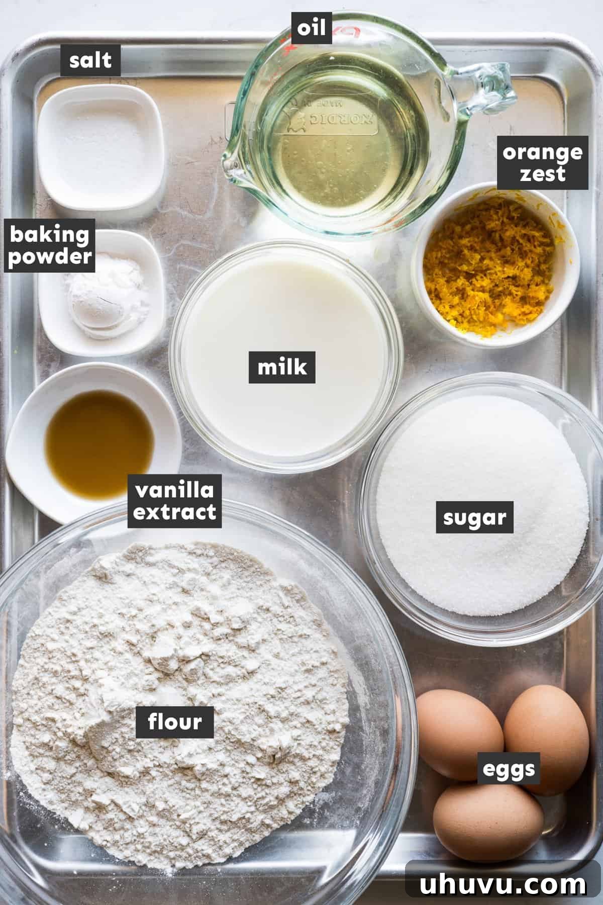 Spanish Muffins 3 Ingredients for Mantecadas laid out on a table, including eggs, sugar, flour, milk, and oil.