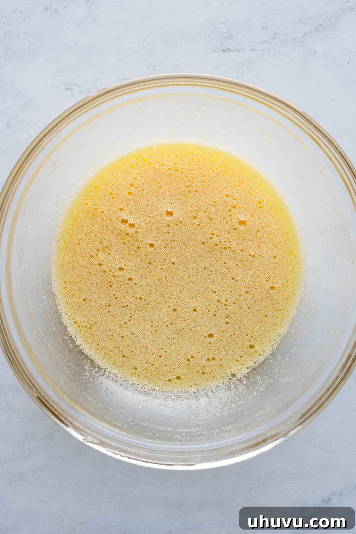 Spanish Muffins 4 Eggs and granulated sugar being whisked together in a mixing bowl until pale yellow.