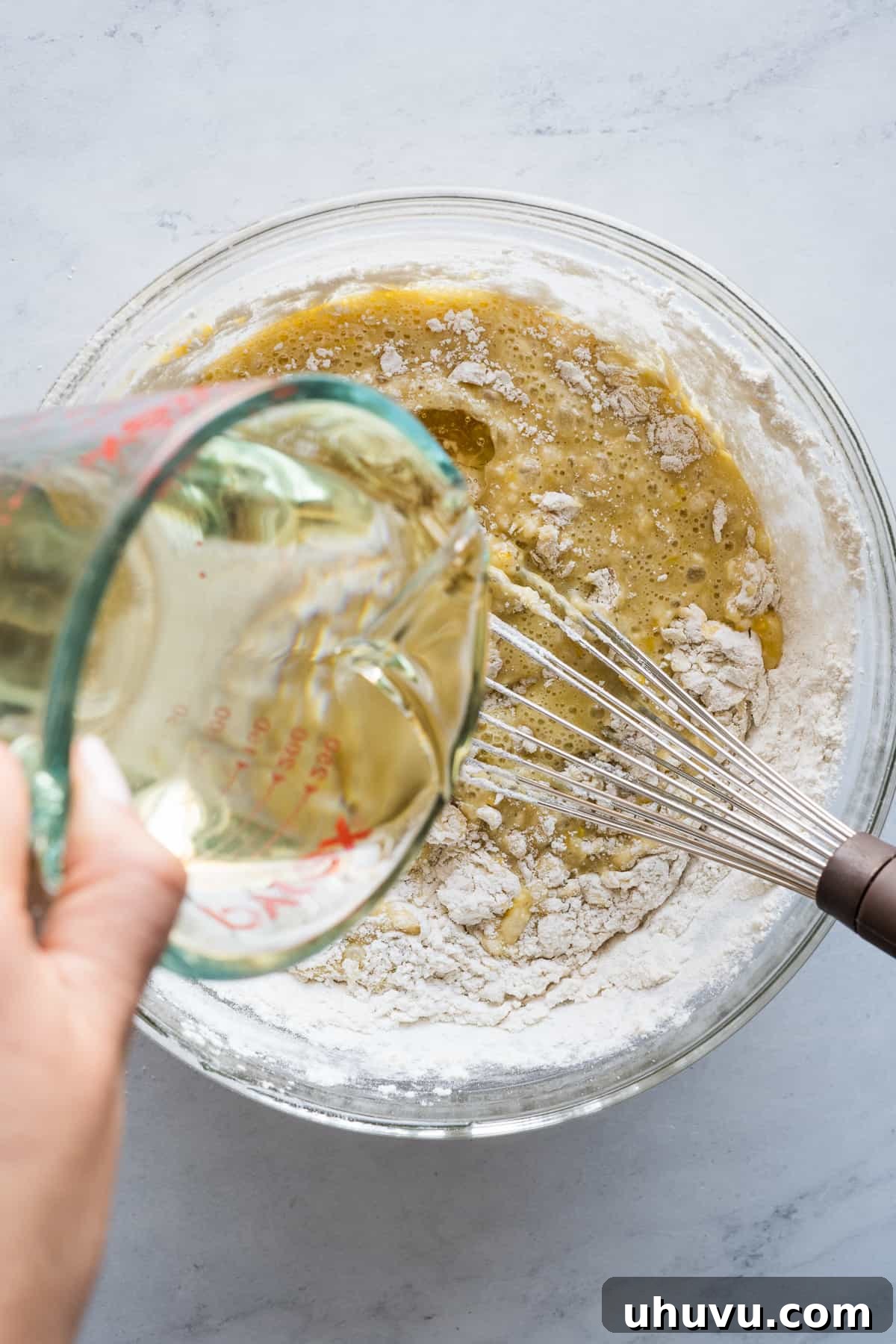 Spanish Muffins 7 Vegetable oil being poured into the partially mixed mantecada batter.