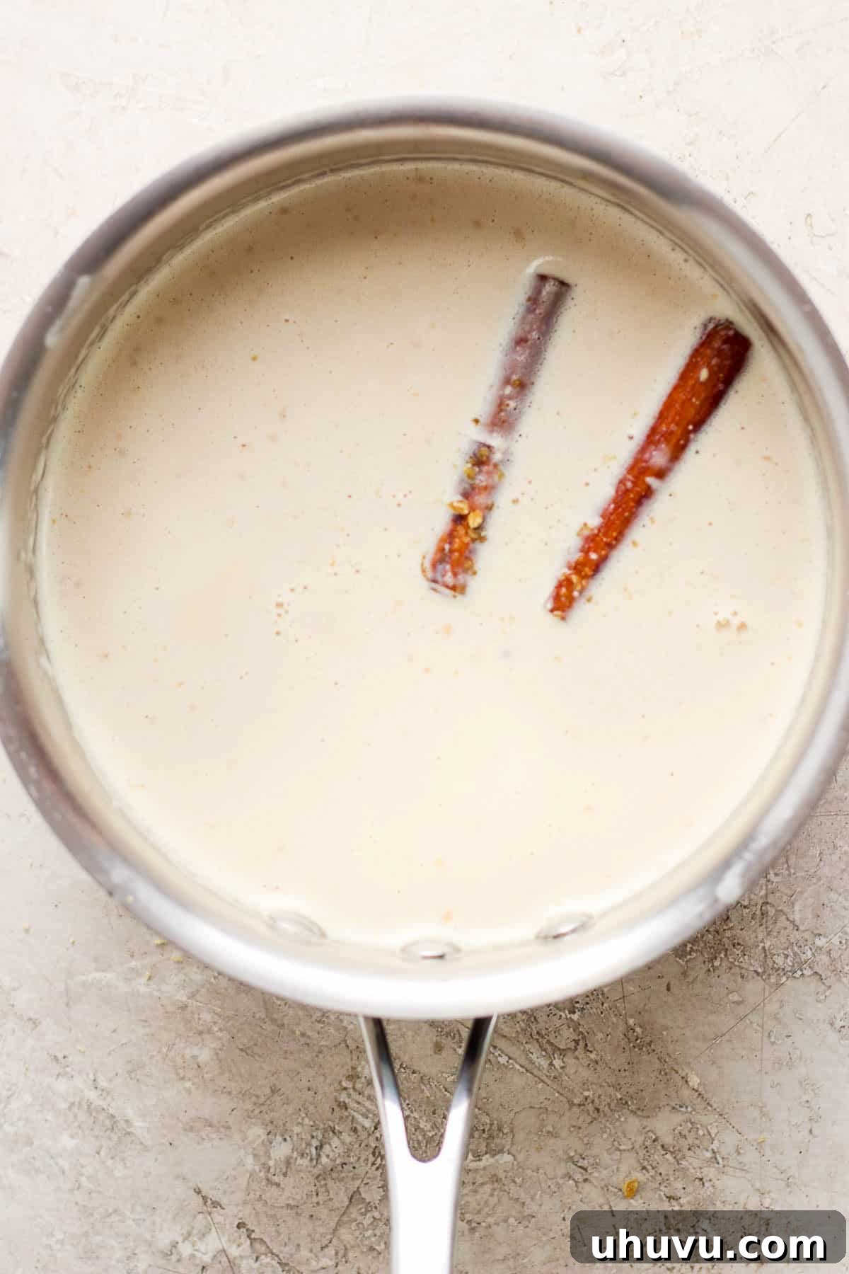 Homestyle María Biscuit Atole 7 Warmed milk mixture in a pot for atole de galletas.