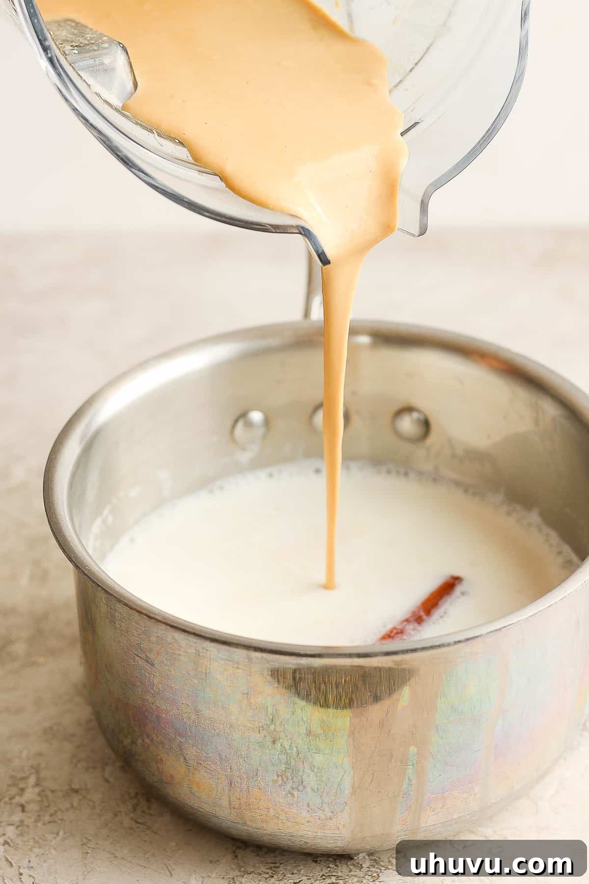 Homestyle María Biscuit Atole 8 Blended marias cookies mixture being poured into a saucepan of hot milk.