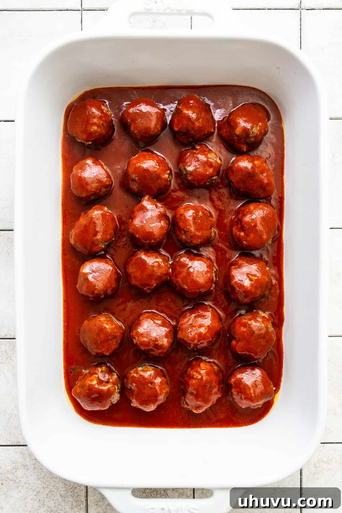 Smothered Enchilada Meatballs 6 Enchilada sauce poured on top of meatballs in a baking dish.
