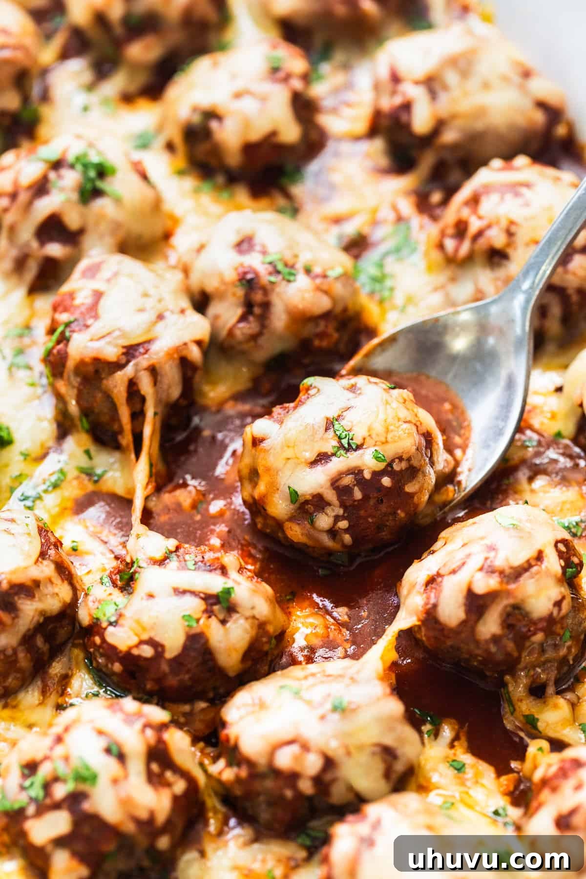 Smothered Enchilada Meatballs 7 Enchilada meatballs in red enchilada sauce with melted cheese on top.