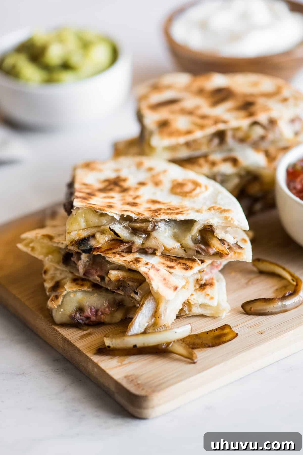 Top 20 Irresistible Mexican Bites for Your Epic Fiesta 9 Perfectly grilled steak quesadillas, sliced and ready to serve on a cutting board.