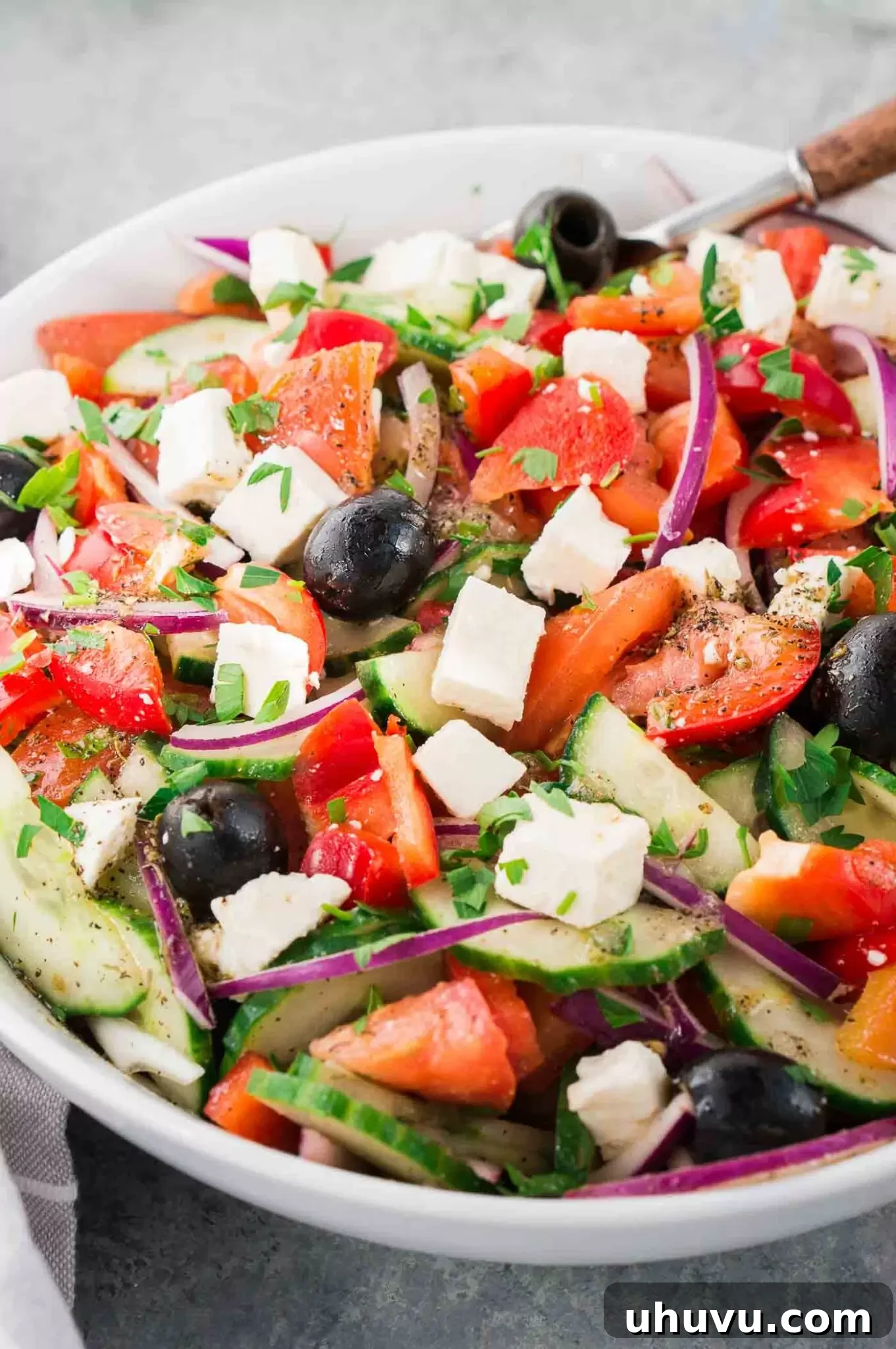 Freshly prepared Greek salad in a white serving bowl
