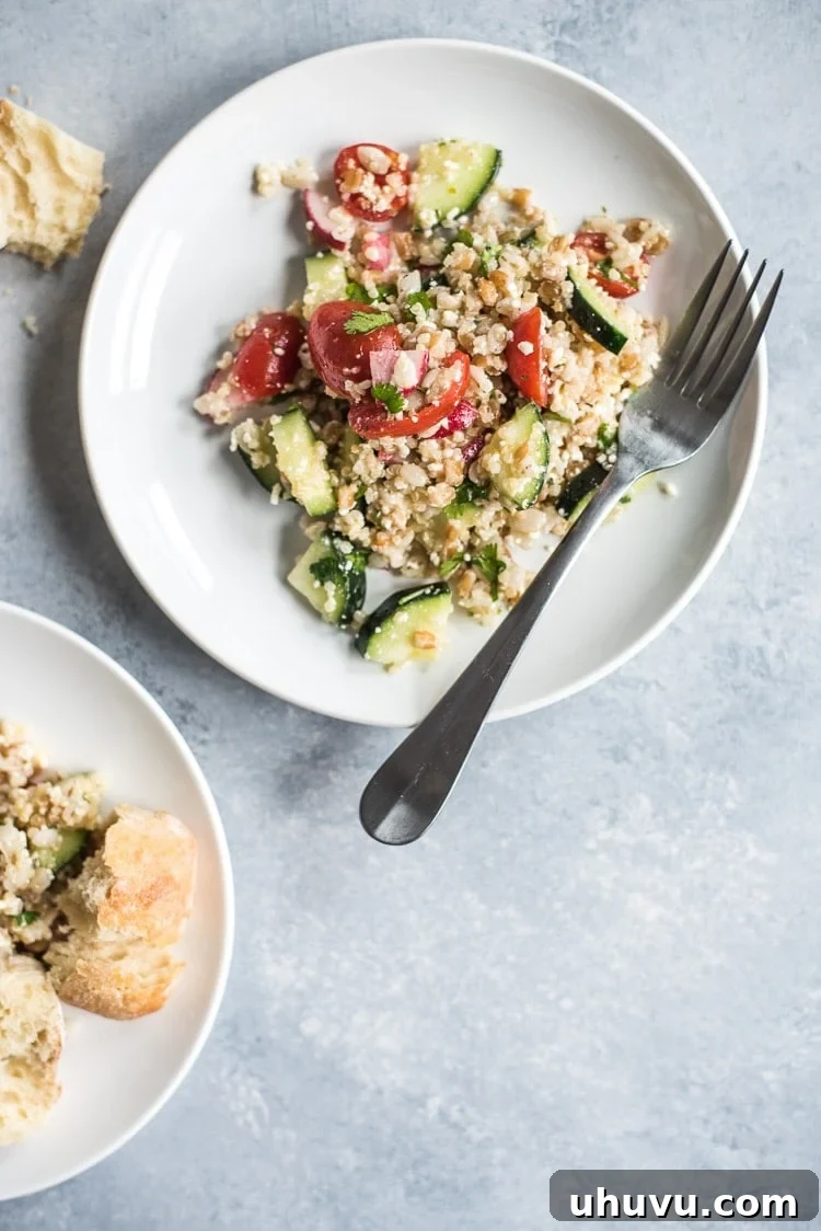 A large bowl of fresh Mexican Quinoa Salad with Farro and Barley, garnished with cilantro and cotija cheese.