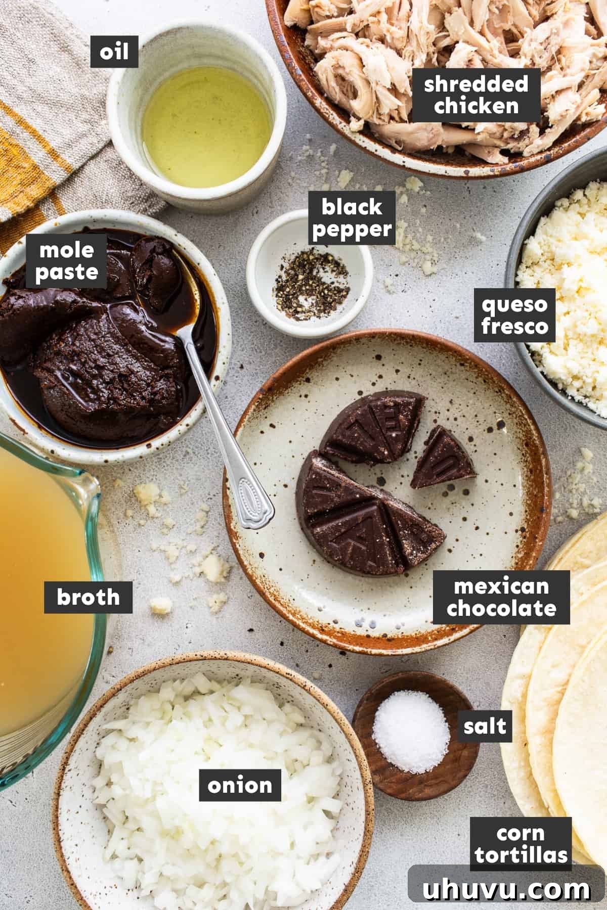 Mexican Mole Bliss 3 A beautifully arranged collection of fresh ingredients for enmoladas, including shredded chicken, mole paste, Mexican chocolate, tortillas, and garnishes, ready for preparation on a rustic wooden table.