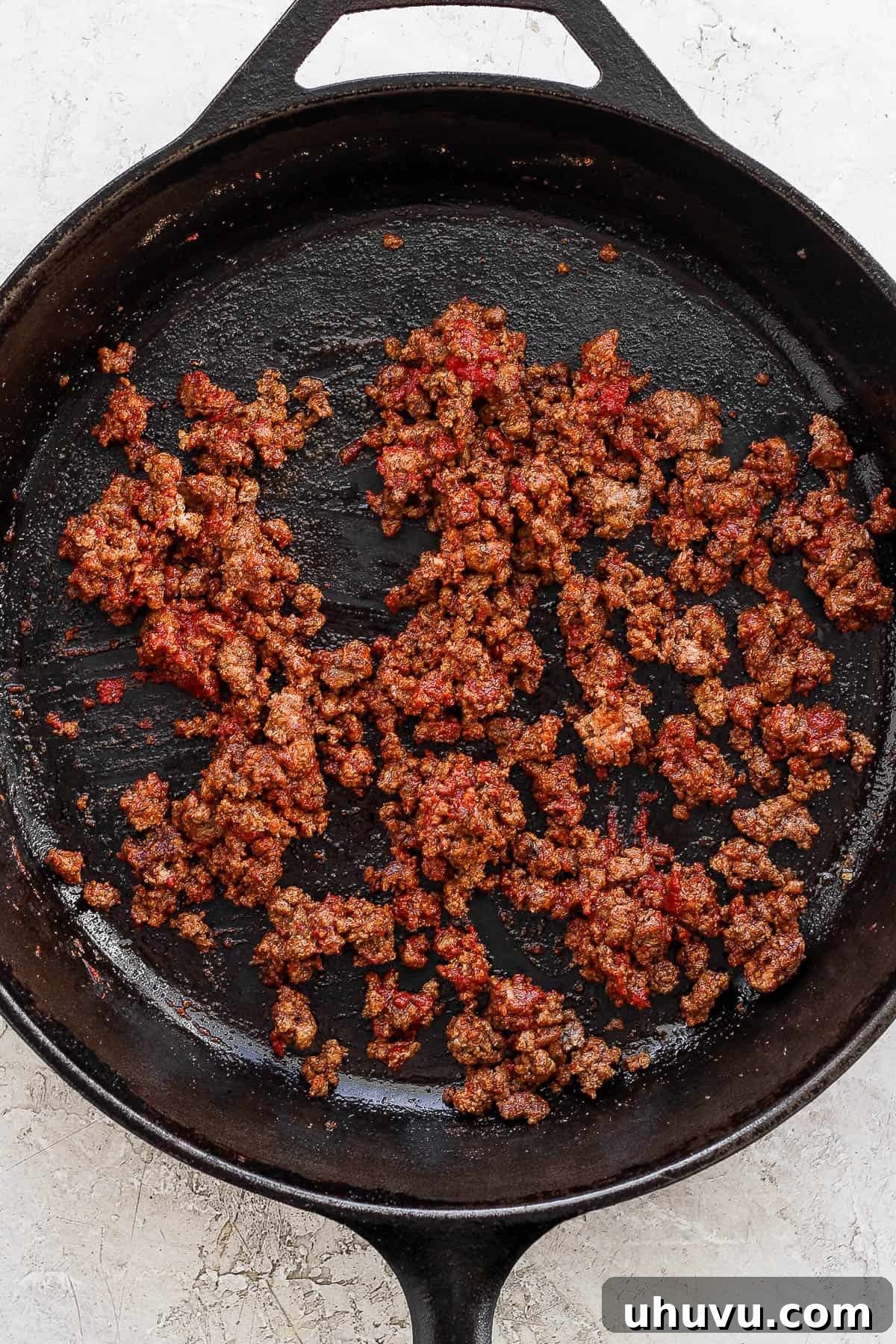 Zesty Mexican Pizza 5 Taco meat being fully cooked and crumbled in a cast iron skillet, ready for pizza assembly.